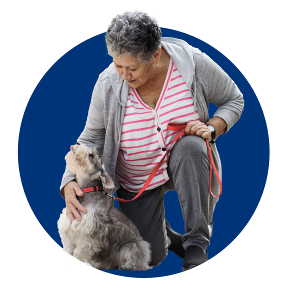 Elderly woman bending down to pet a dog